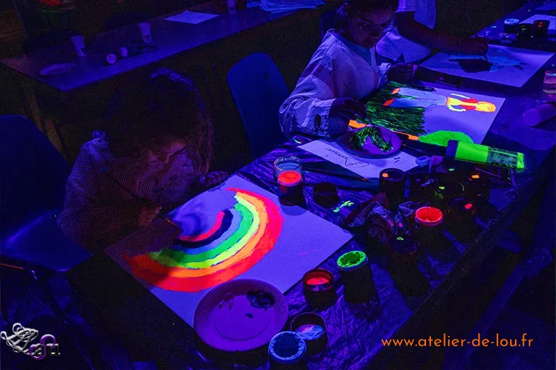 Enfants peignant sous lumière UV pendant un anniversaire Peinture dans le Noir à Reims